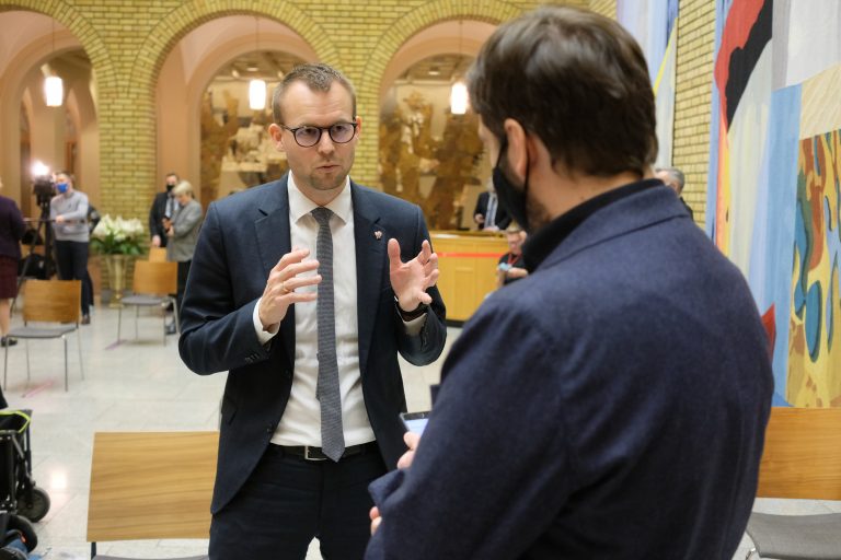 Kjell Ingolf i samtale med journalist i vandrehallen på Stortinget
