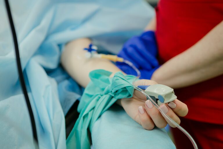 Dame ligger på sykesengen med intravenøs