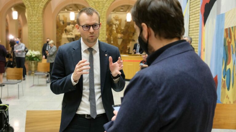 Kjell Ingolf Ropstad står i Stortingets vandrehall og snakker med en journalist